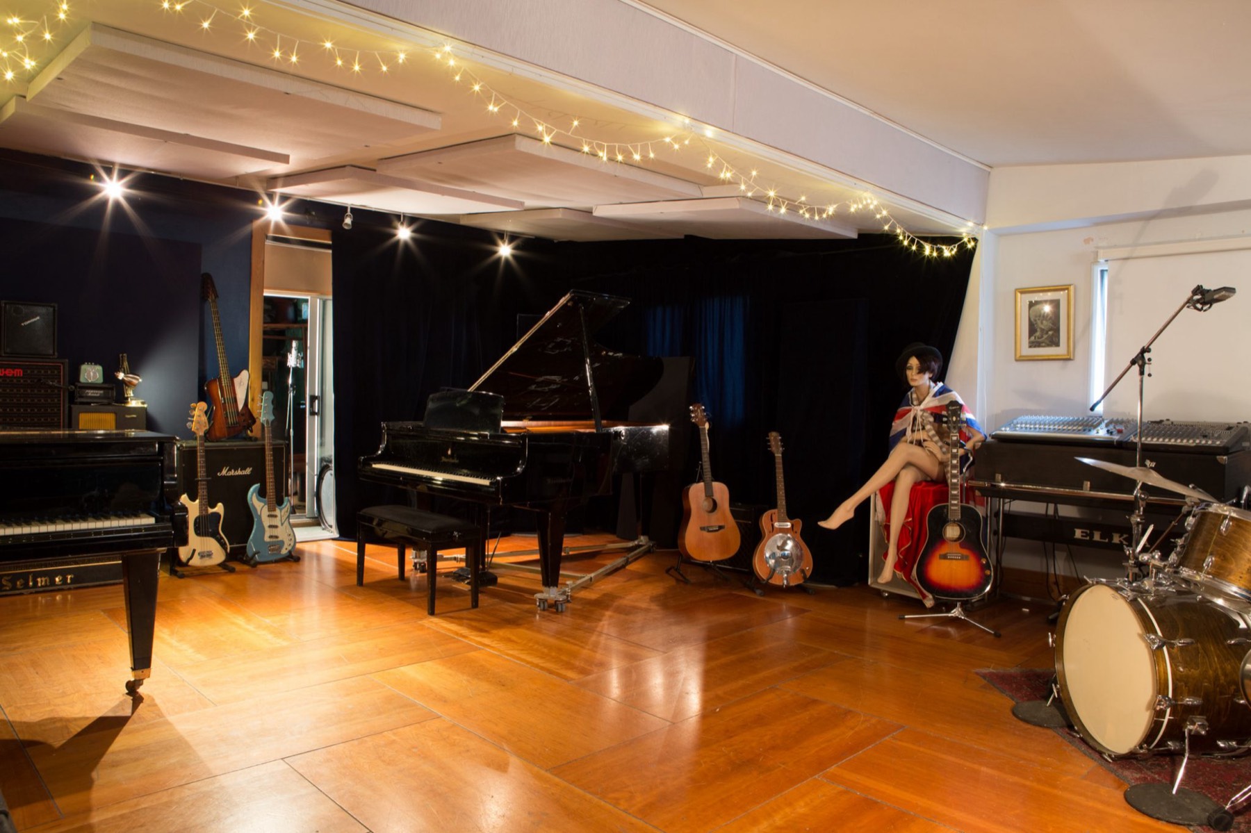 The Love Electric live room: hardwood floor, Bösendorfer grand, drum kit and guitars under warm lights