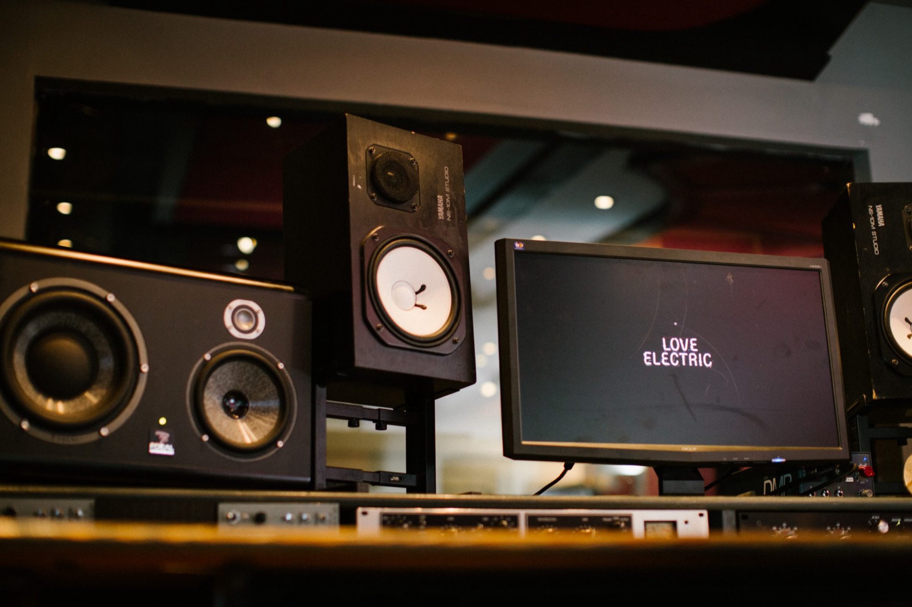 Control room with Focal and Yamaha monitors either side of a screen reading Love Electric