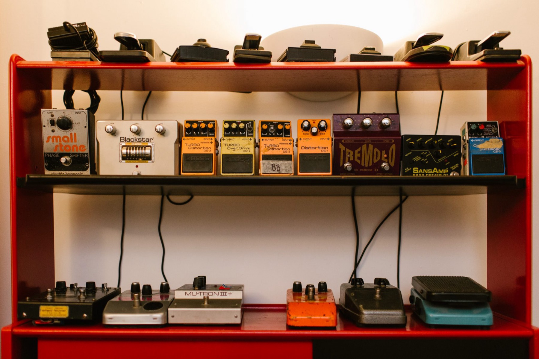 Red shelves of guitar pedals